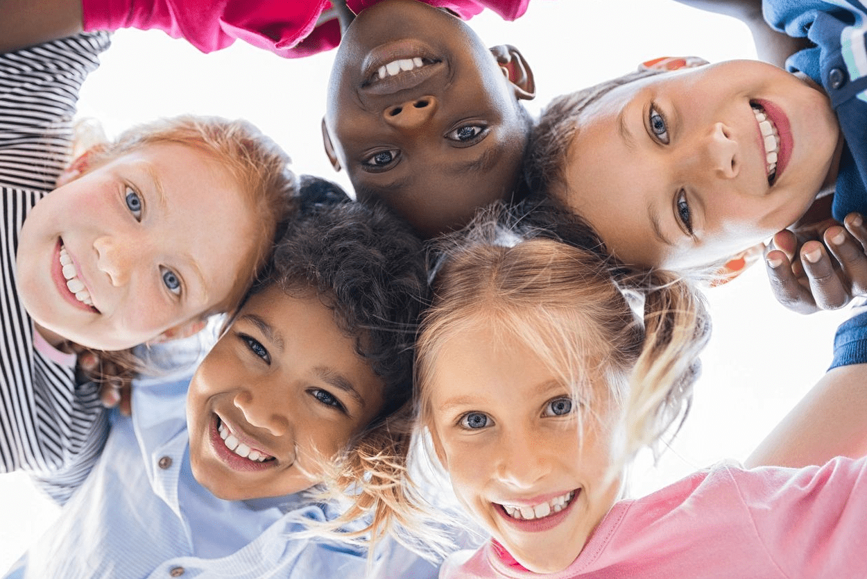 A group of children with their heads together.